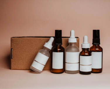 Szklane buteleczki z kosmetykami i karton