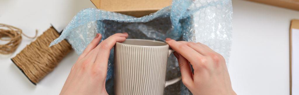 Pakownanie kubka do kartonu wyłożonego folią bąbelkową